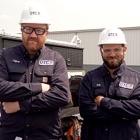 Two OTC technicians standing with their arms crossed